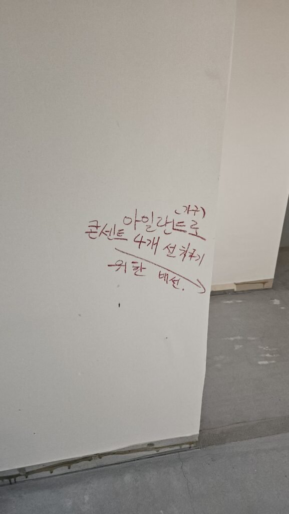 주방 아일랜드 콘센트 4개 설치를 위한 배선 위치를 표시한 벽면 메모