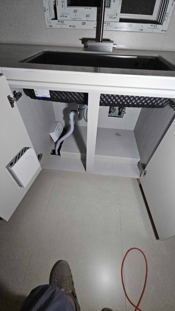 싱크대 하부 온수분배기를 가구 pet로 가려서 깔끔하게 만든 모습
